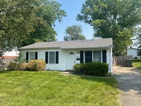 Louisville house for rent - A white house with a black roof and a green lawn.