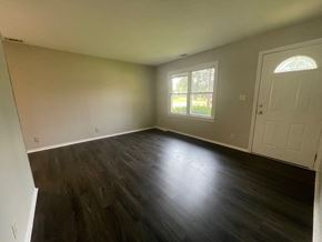 Louisville house for rent - A room with a wooden floor and a white door.