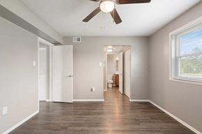 Clarksville apartment for rent - a living room with a ceiling fan and a hallway to a bathroom