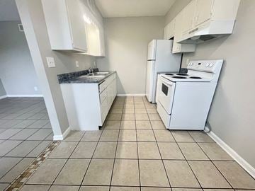 Louisville apartment for rent - an empty kitchen with white appliances and white cabinets