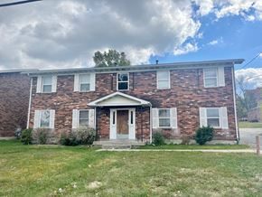 Louisville apartment for rent - a brick house with a cloudy sky in the background