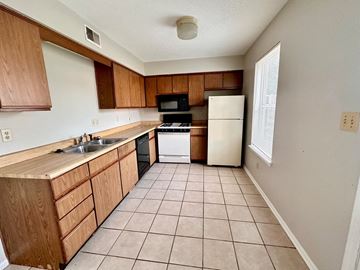 Corydon apartment for rent - a kitchen with wooden cabinets and a white refrigerator