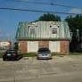 Metairie apartment for rent - a building with a green roof and two cars in front of it