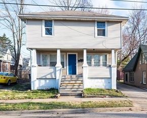 Akron apartment for rent - A two-story house with a blue door and white trim.