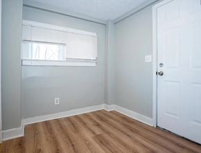 Akron apartment for rent - A room with a white door and a window with blinds.