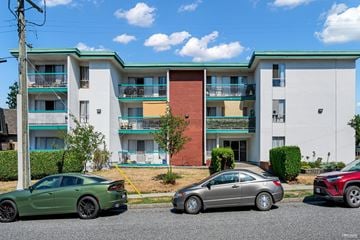 North Vancouver apartment for rent - A green car is parked in front of a multi-story apartment building.