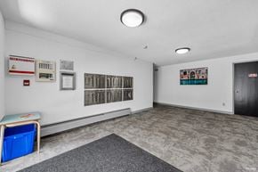North Vancouver apartment for rent - A room with a grey carpet and a blue bin on the floor.