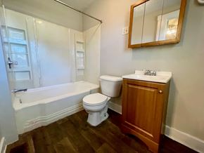 Louisville house for rent - A white toilet sits next to a white sink in a bathroom.