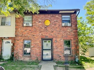 Louisville house for rent - A red brick house with a black door and windows.