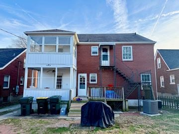 Louisville apartment for rent - A two-story house with a red brick exterior and a white garage door.