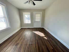 Louisville house for rent - an empty living room with hardwood floors and white walls