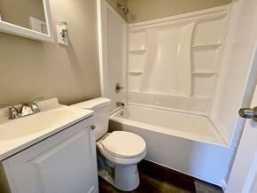 Louisville house for rent - a bathroom with a toilet and a tub and a sink