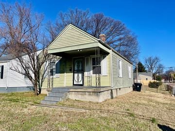 Louisville house for rent - the front of a yellow house with stairs and a door