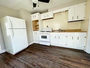 Louisville house for rent - an empty kitchen with white appliances and white cabinets