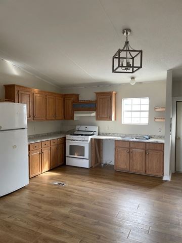 Pagosa Springs house for rent - A kitchen with wooden cabinets and a white fridge.