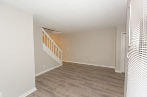 New Albany apartment for rent - an empty living room with wood floors and a white staircase
