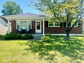 Louisville house for rent - a small brick house with a porch and a tree