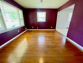 Louisville house for rent - an empty living room with purple walls and wooden floors