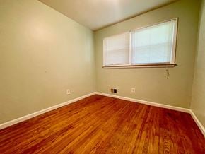 Louisville house for rent - an empty bedroom with wood floors and a window