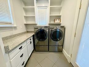 Louisville house for rent - a washer and dryer in a laundry room with white cabinets