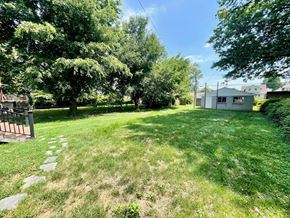 Louisville house for rent - a backyard with a house and a yard with grass and trees