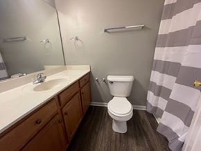 Sellersburg apartment for rent - A bathroom with a toilet, sink, and mirror.
