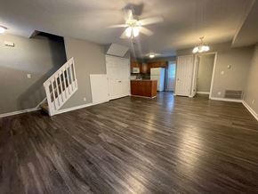 Sellersburg apartment for rent - A room with a ceiling fan and wooden flooring.
