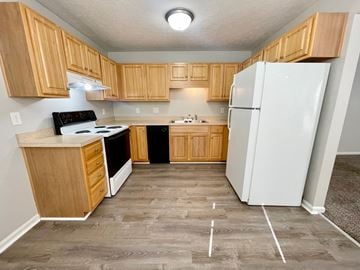 New Albany apartment for rent - A kitchen with wooden cabinets and a white refrigerator.