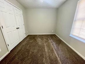 New Albany apartment for rent - A room with a carpeted floor and a white door.