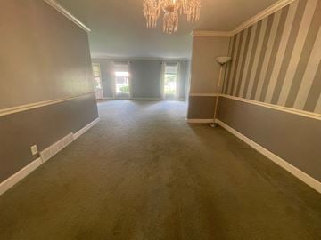 Louisville house for rent - a living room with a carpet and a chandelier