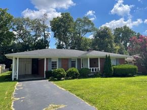 Louisville house for rent - a small brick house with a driveway and a lawn