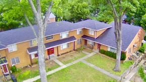 Louisville apartment for rent - A house with a red door is surrounded by trees.