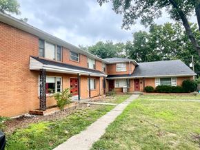 Louisville apartment for rent - A brick house with a red door and a small front yard.