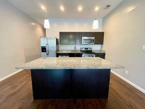 Louisville house for rent - A kitchen with a granite countertop and dark wood cabinets.