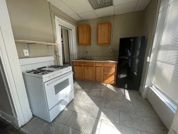 Louisville apartment for rent - A kitchen with a white gas stove and black refrigerator.