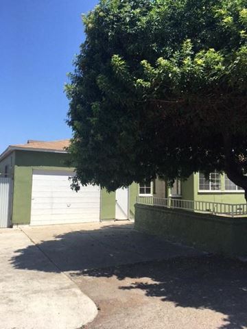Chula Vista house for rent - a green house with two garage doors and a tree