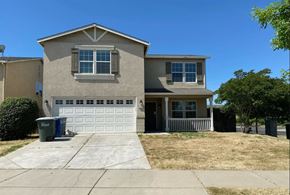 Merced house for rent - a house with a driveway and a garage door