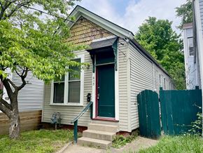 Louisville house for rent - A small house with a green door and a red step.