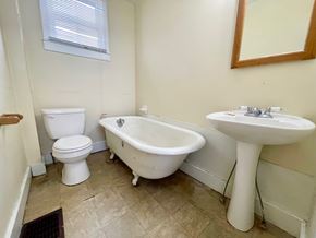 Louisville house for rent - A white toilet sits next to a white sink in a bathroom.