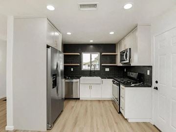 San Diego house for rent - a kitchen with white cabinets and a stainless steel refrigerator