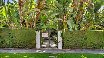 Los Angeles apartment for rent - A gate with a sign that says "No Trespassing" is surrounded by greenery.