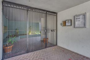 Los Angeles apartment for rent - A metal gate is closed in front of a glass door.