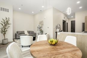 Rochester Hills apartment for rent - A modern dining room with a wooden table and white chairs.