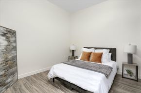 Rochester Hills apartment for rent - A bedroom with a large bed and a painting on the wall.