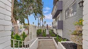 Los Angeles apartment for rent - A narrow alley with white walls and a metal railing.
