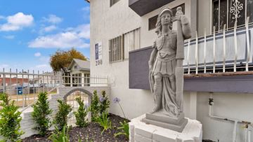 Los Angeles apartment for rent - A statue of a man holding a woman is in front of a building with the number 200 on it.