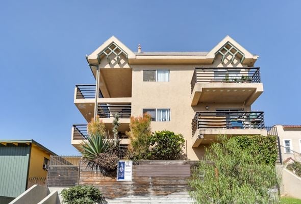 Los Angeles apartment for rent - A modern two-story building with balconies and a clear blue sky in the background.