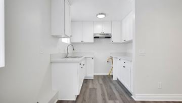 Los Angeles apartment for rent - A kitchen with white cabinets and a wooden floor.