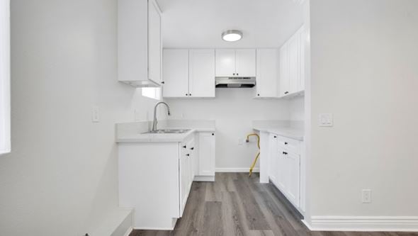 Los Angeles apartment for rent - A kitchen with white cabinets and a wooden floor.