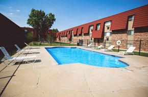 Amarillo apartment for rent - a resort style pool is in front of a red building
